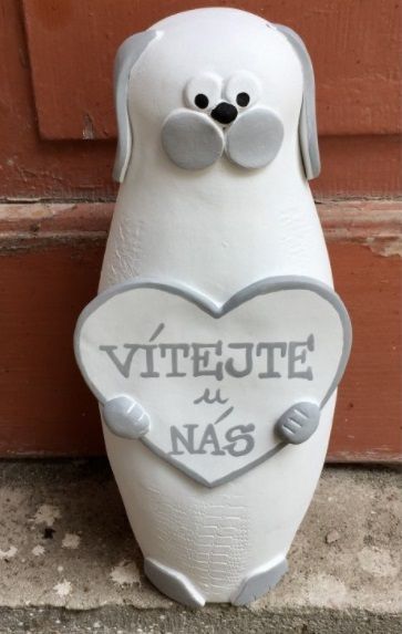 Spokojen&yacute; pes - dekorativn&iacute; postavička, kter&aacute; je určena i ven k brance či ke dveř&iacute;m. Pes drž&iacute;c&iacute; tabulku - v&iacute;tejte u n&aacute;s.